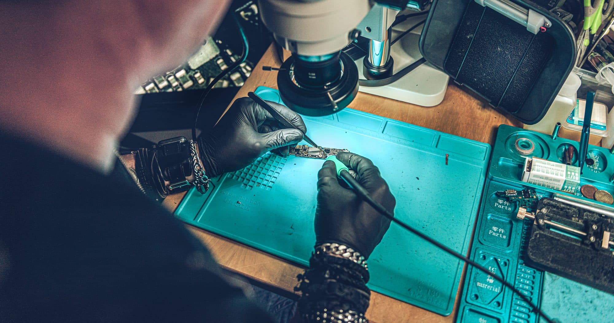 Martijn repareert een moederbord onder de microscoop